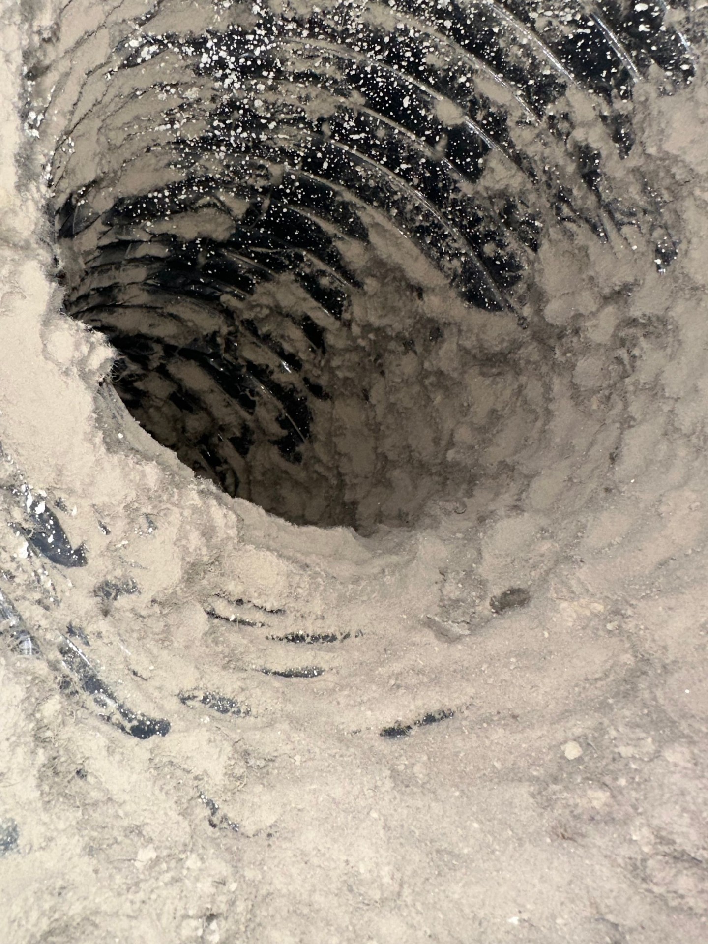 Close-up of a dirty residential air duct showing dust and debris buildup before professional cleaning