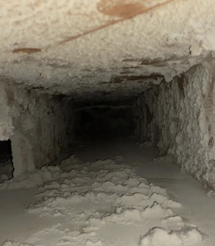 Close-up of a dryer vent line clogged with lint buildup before Vortex cleaning