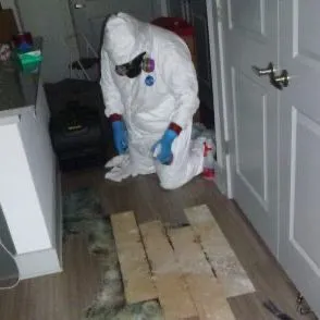 Technician in PPE performing biohazard contamination cleanup